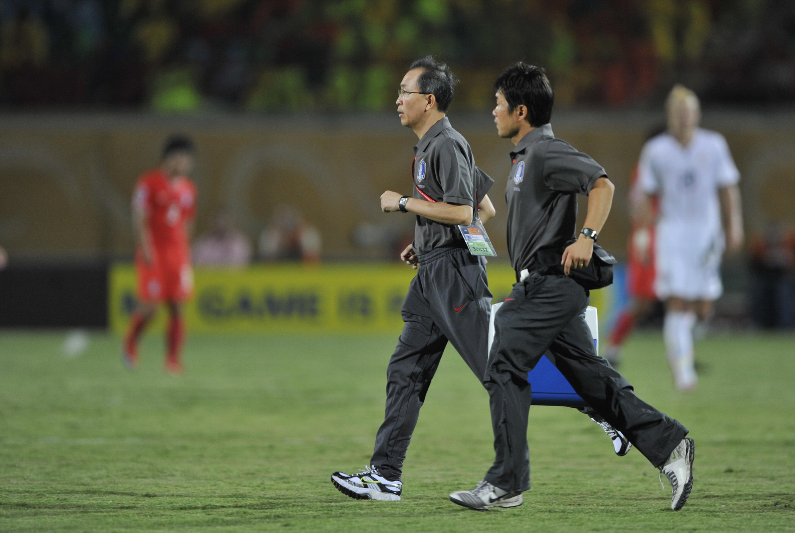 나영무 솔병원 원장(왼쪽)이 축구 국가대표 경기에서 부상 선수가 발생하자 경기장 안으로 뛰어가고 있다.