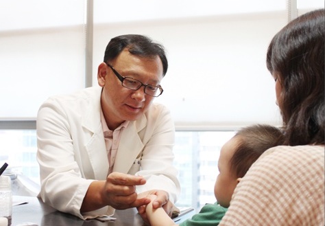 김정진 아토파인한의원 원장이 아토피피부염으로 고생하는 어린이 환자를 진료하고 있다.