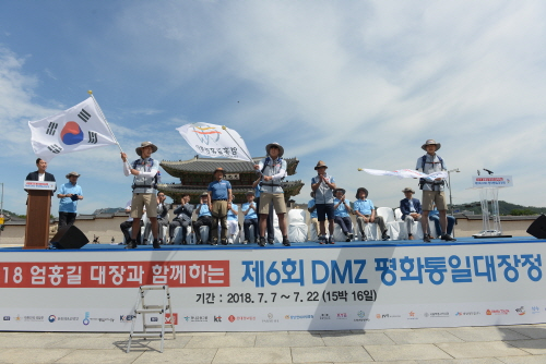 ‘2018 엄홍길 대장과 함께하는 제6회 DMZ 평화통일대장정’ 참가자들이 지난 7일 오전 10시 광화문 광장에서 열린 발대식에서 깃발을 흔들며 환호하고 있다.