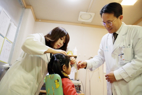 박홍주 서울아산병원 이비인후과 교수(오른쪽)가 소아난청 환자를 진료하고 있다.